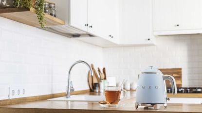 Mini smeg kettle in blue on wooden kitchen countertop